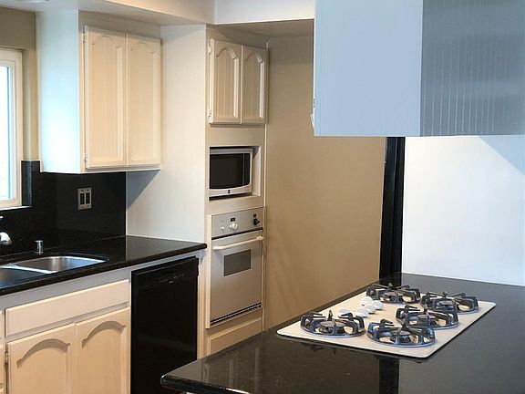 Kitchen with Thermador oven, stovetop, dishwasher, fridge, and disposal.