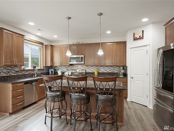 Open concept kitchen with granite, stainless appliances (staying with home) and walk-in pantry