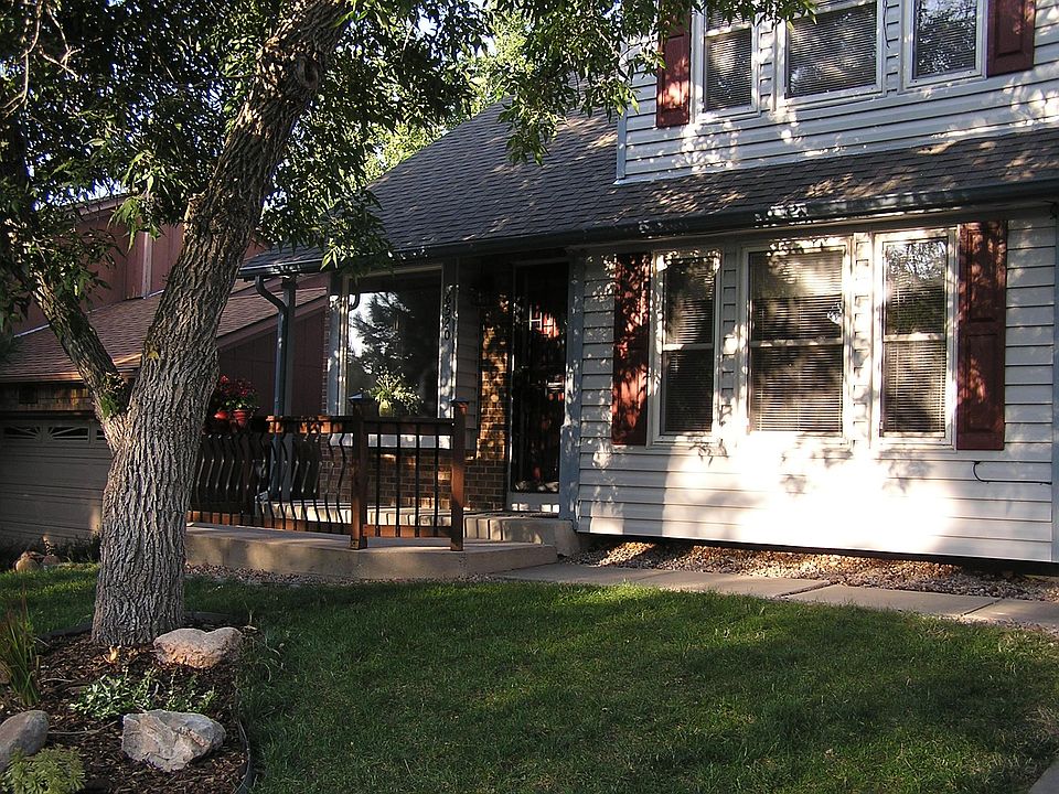 An inviting front porch, mature trees, and landscaping
