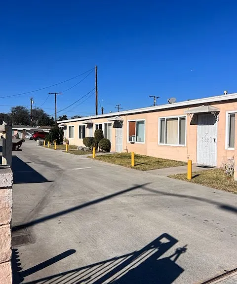 This single-story apartment complex has a dedicated parking lot, grassy entrances to each unit, and laundry facilities for renters.