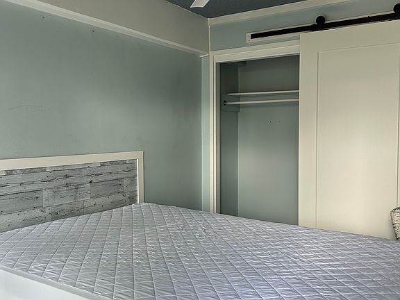 Bedroom with Full size bed and Barn Door for Closet which doubles as entrance door to bedroom.
