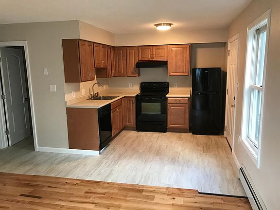 Updated kitchen with new cabinets, appliances, lighting and flooring. Bathroom door is shown to the left.