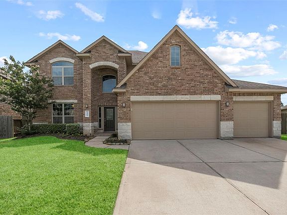 Lush lawn, winding walkway and brick and stone front exterior add to the lovely curb appeal of this home.