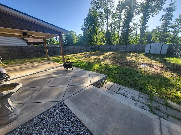 Large, level, fenced back yard, with covered concrete patio and storage building for your use.