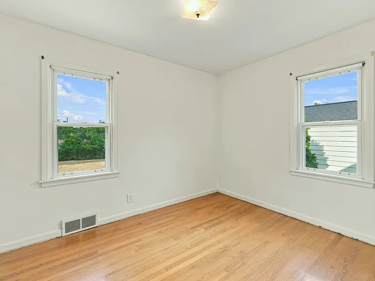 View walking into the guest bedroom of private backyard and wooded evergreen views.