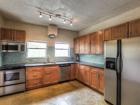 The kitchen features stained concrete floors, granite counters, stainless steel appliances and plent