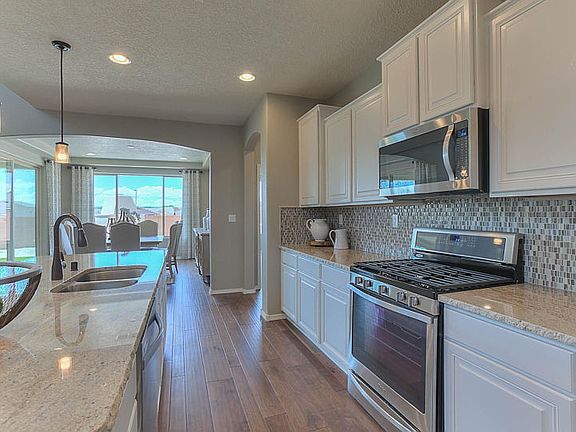 Messina kitchen shown with white cabinets, granite countertops, and stainless steel appliances.