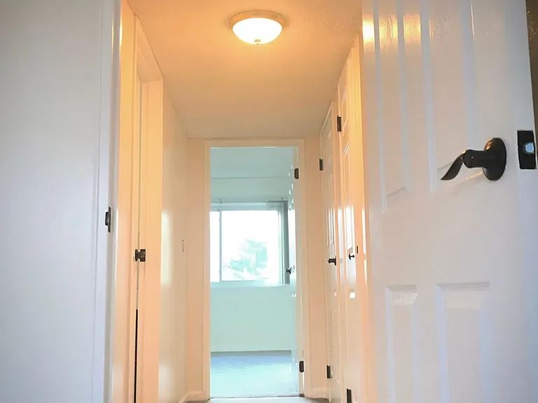 Hallway from 2nd bedroom to master suite. Updated light fixtures throughout