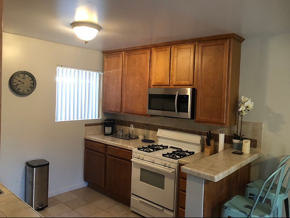 Right side view of kitchen with built-in microwave, and eat-in bar.