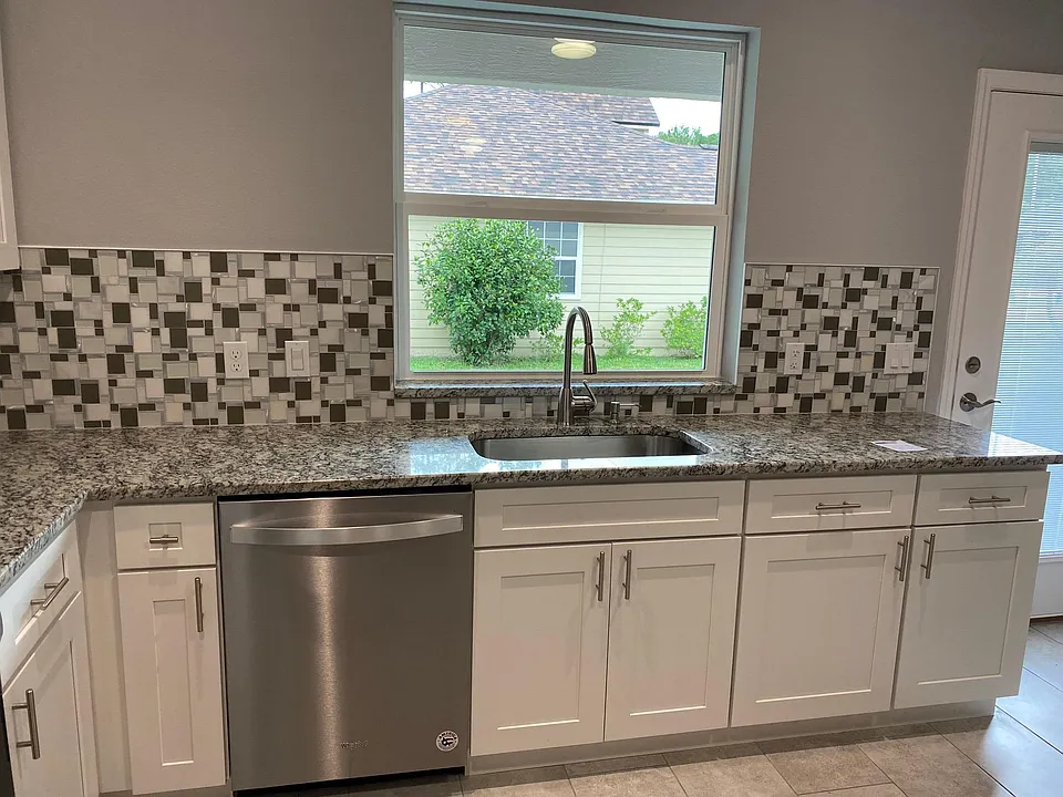 Large kitchen sink with tall modern faucet.