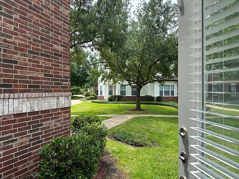 Inviting view of a charming residential area with lush greenery, a mature tree, and classic brick facade, enhancing the suburban tranquility. Inviting view of a charming residential area with lush greenery, a mature tree, and classic brick facade, enhanci