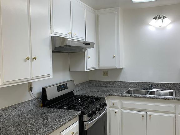 Kitchen with gas stove and granite counters.