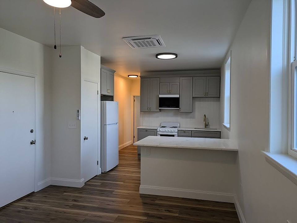 Kitchen with tile backsplash and quartz countertops.