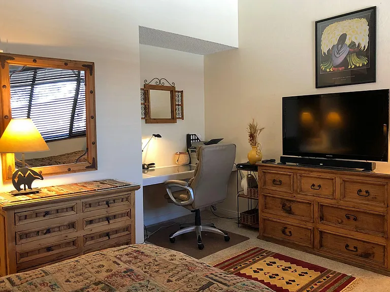 The master bedroom has two horizontal dressers and a desk area.