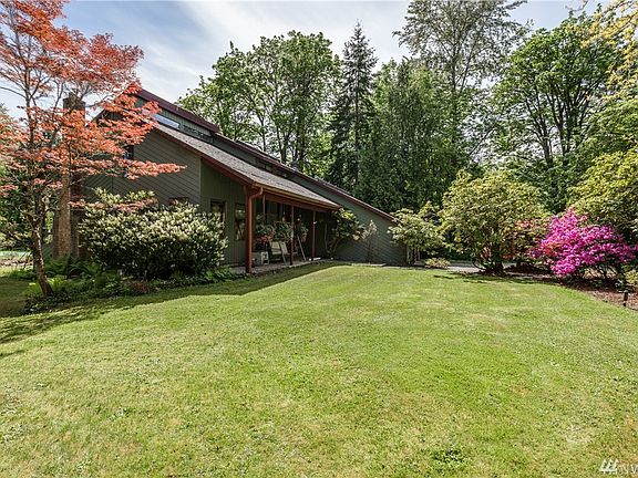 Large front lawn area surrounded by beautiful landscaping