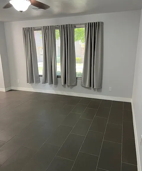 Living Room: Front Window, New Curtains, Tile and Grout Flooring, Freshly Painted Ceiling, Walls, Baseboards, Doors and Moldings, Ceiling Fan with Light.