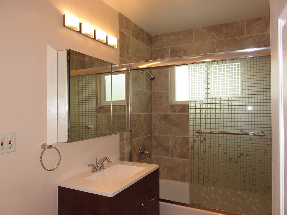 Bathroom, toilet,tiles,bathtub, shower and glass sliding door. Sink/commode. Med. cabinet/mirror.