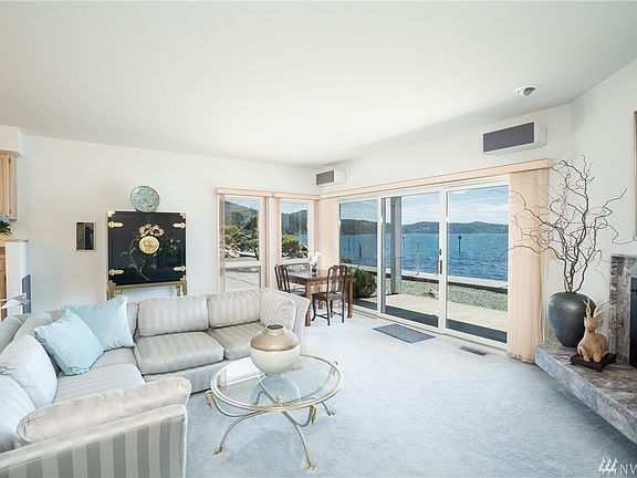 Large and open living room is steps to the water.
