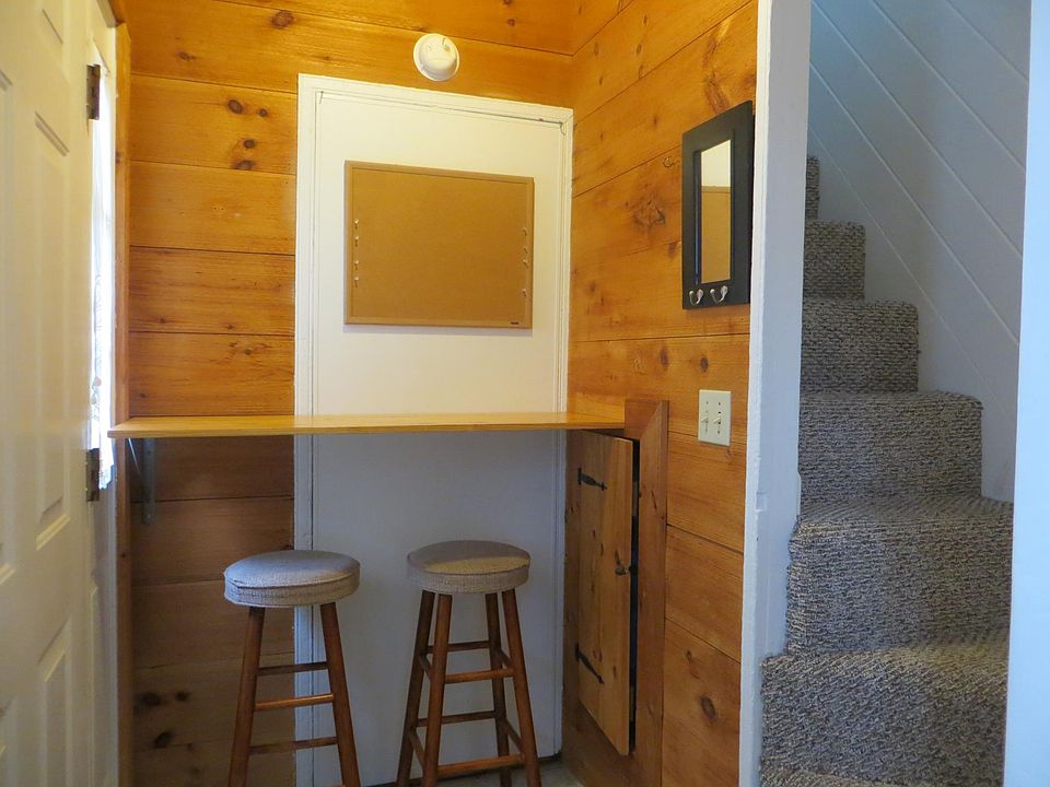 Front entry door/Across from kitchen/ eating in area with seating and small closet underneath. Notice steep, narrow stairs going up to a beautiful open loft.
