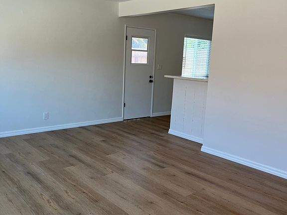 Living room that_s open to kitchen and door in the kitchen goes out to private outdoor space