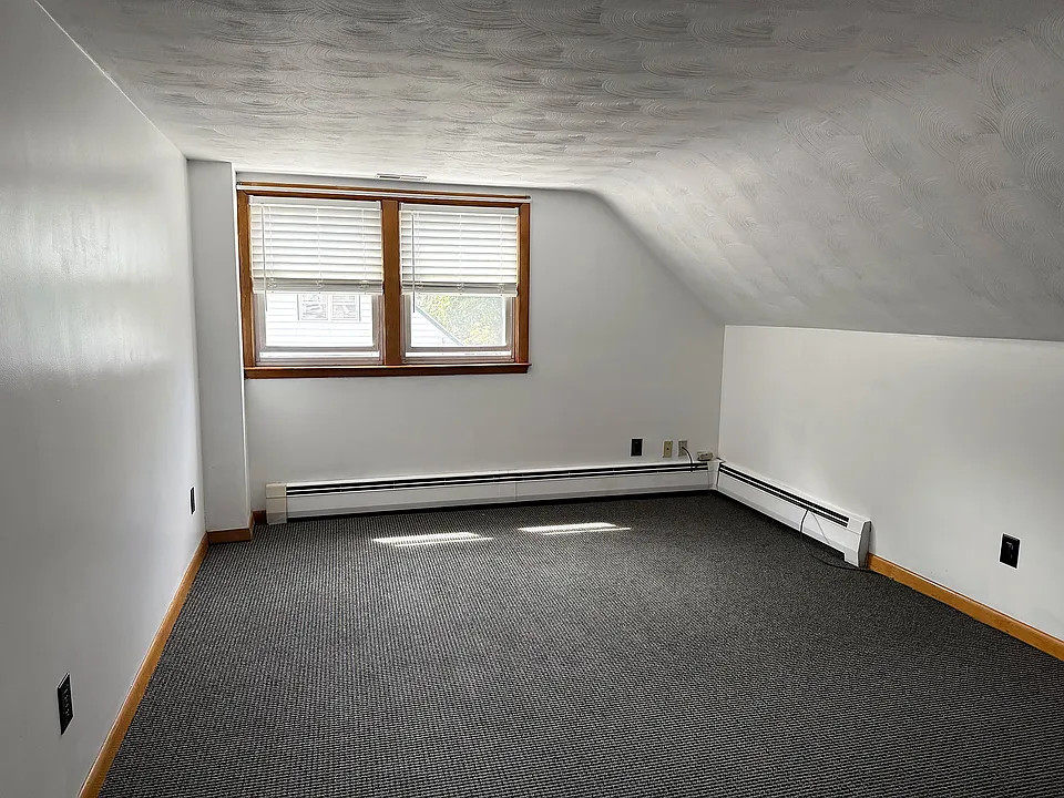 Living room under sloped ceilings, comfy in New England winter nights.