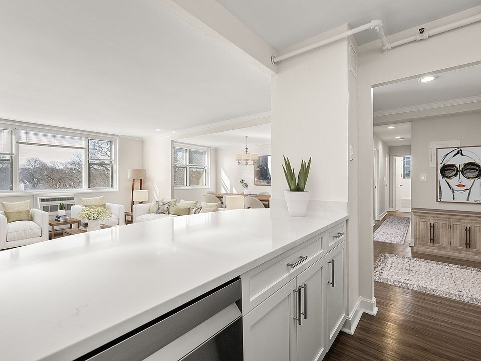 Bright and inviting living space with elegant decor, large windows, and modern quartz kitchen counter detail at Parkside Place, apartments in Cambridge, MA