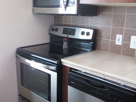 Kitchen features ear new stainless steel appliances and custom tile
