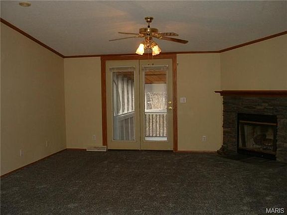Vaulted family room with w/b fireplace & double doors leading ou