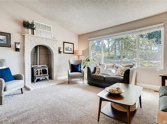 Bright living room wood stove to keep you warm on those cold winter nights. Notice the updated double pane windows throughout.