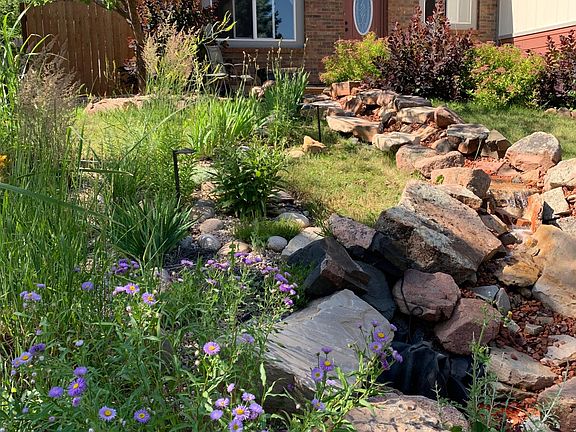 Peaceful waterfall with Colorado moss rock to listen to from inside and native plants