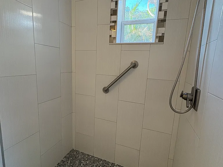 Bathroom shower, note window detail and tile flooring