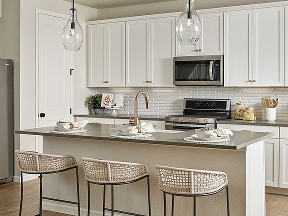 Kitchen with White Cabinetry and Pendant Lighting Over the Island
