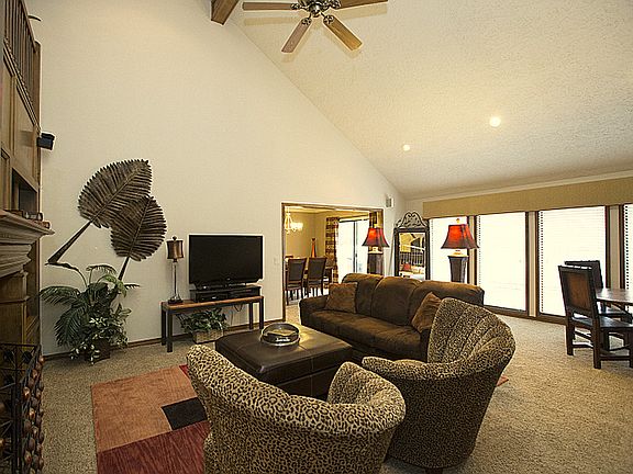 This view of the living room shows the doorway to the formal dining room and wall of windows that overlooks the back lawn.