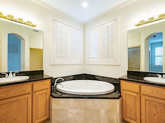 Master bath with dual sinks, granite tops, marble floors and marble walk-in shower with premium glass door.