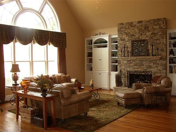 Dramatic Vaulted Family Room with Wall of Windows, Stacked Stone Fireplace,
