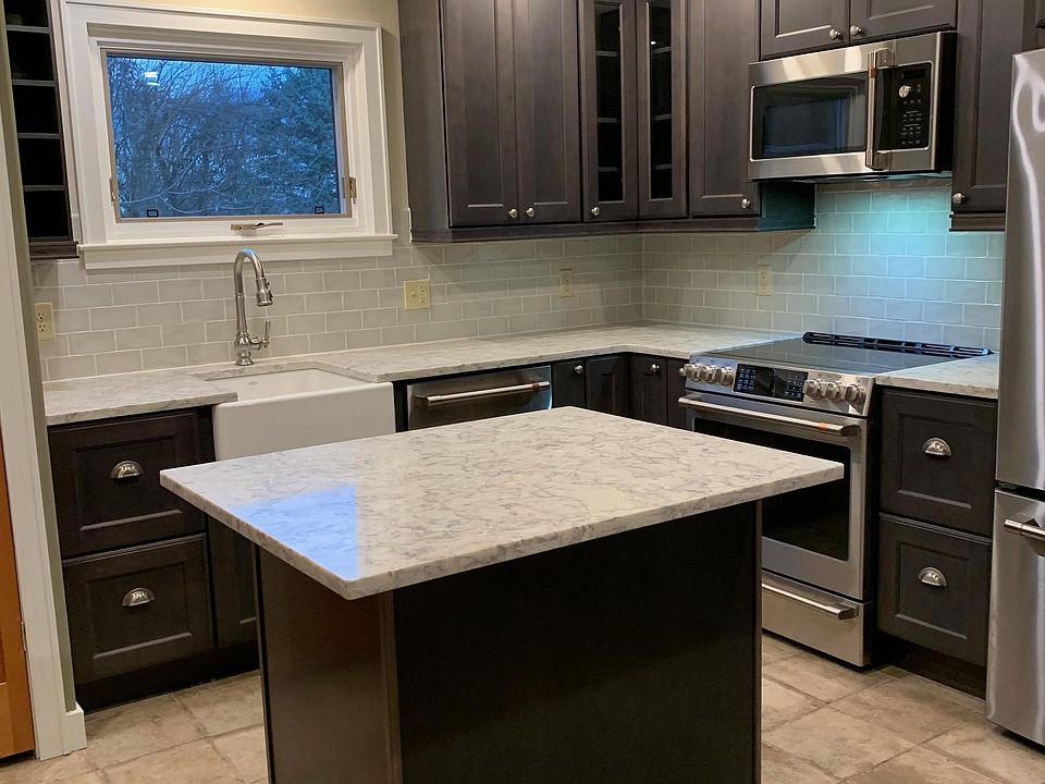 Beautifully appointed kitchen with island, porcelain tile floors, Cafe appliances, quartz countertops