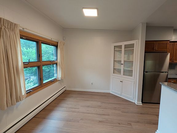 Bright dining area with corner built-in and lush views of the creek.