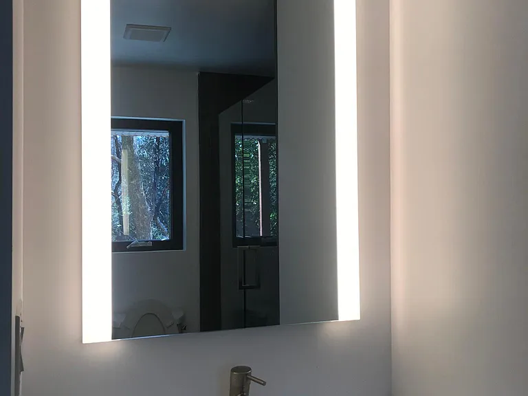 Luxurious custom bathroom with lighted mirror for perfect makeup application.