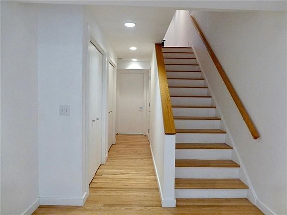 Entrance hardwood floors, stairs to living area, powder room, laundry and garage
