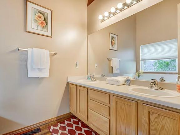 The master bathroom attached to the bedroom has 2 sinks and a high ceiling
