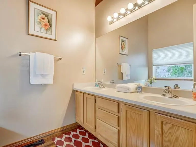 The master bathroom attached to the bedroom has 2 sinks and a high ceiling