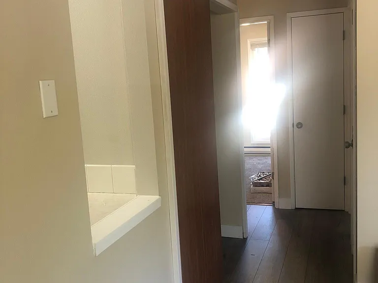 Hallway to bedrooms/bath. Pass through window from kitchen followed by Washer & Dryer closet space.