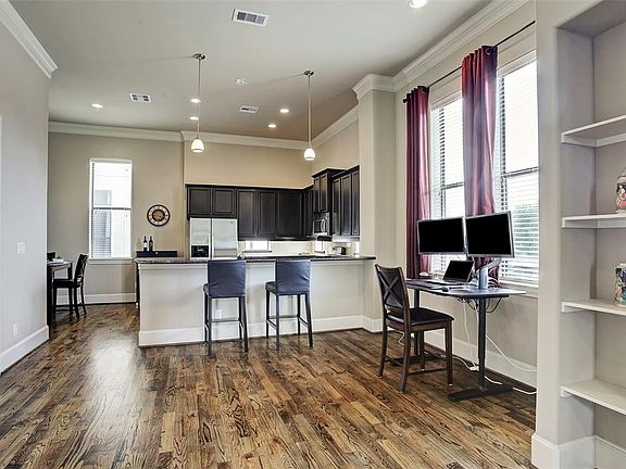 Dining area with oversized windows is currently being used as an office.