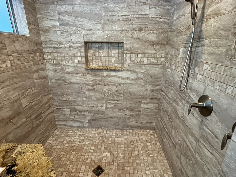 Master bath walk in shower with a bench for sitting