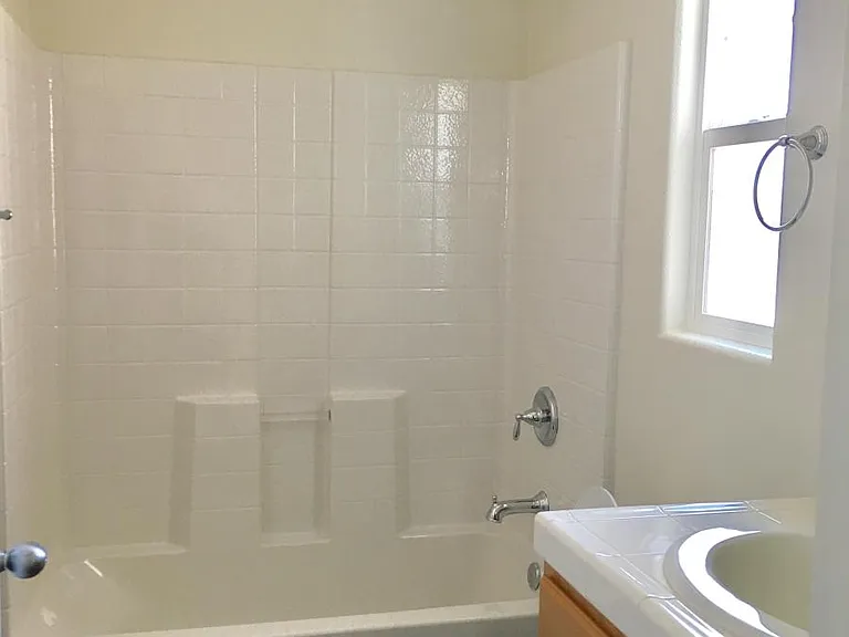 Shared bathroom on the second floor is well lighted, with easy to clean laminate wood floor.