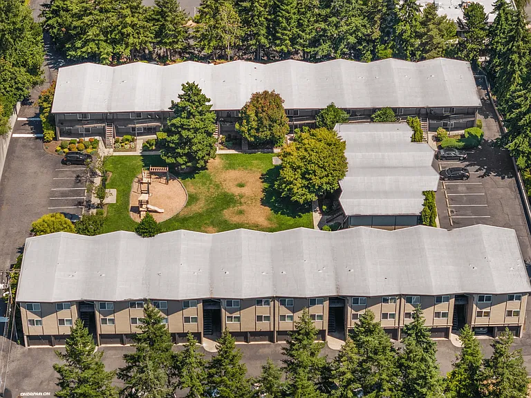 Aerial view of our community's lush courtyard, complete with open green space, shaded seating, and a playground.