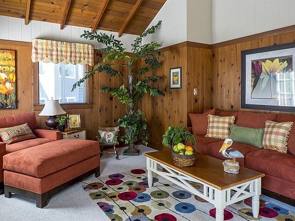 Real wood paneled living room w/high ceilings.