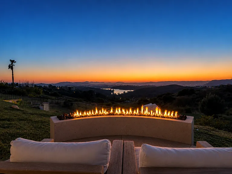 The view from the lower sitting area with a large curved gas fireplace specifically shaped to point towards the lake and the night breeze to keep you warm.
