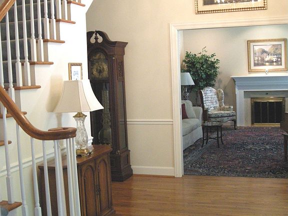 Hardwood entry with turned stair is open to formal living room and dining room