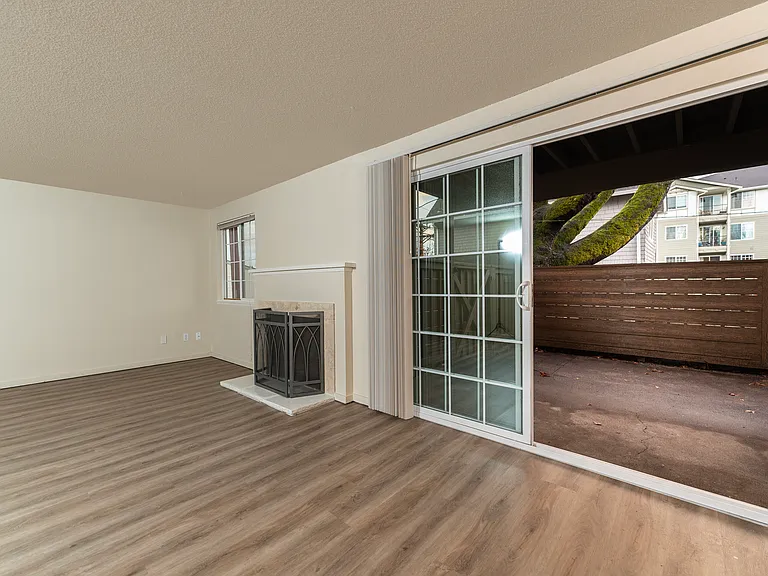 Step into a spacious living room featuring elegant floors and direct access to an inviting patio area. Step into a spacious living room featuring elegant floors and direct access to an inviting patio area.